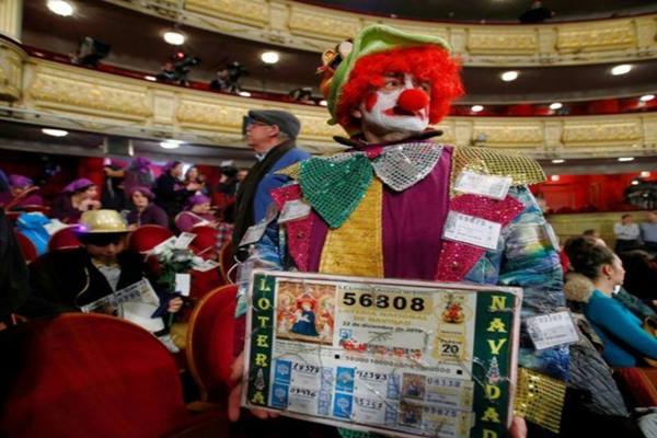 Seseorang mempeihatkan fotokopi tiket undian El Gordo, saat menghadiri undian lotre Spanyol tersebut. - Reuters