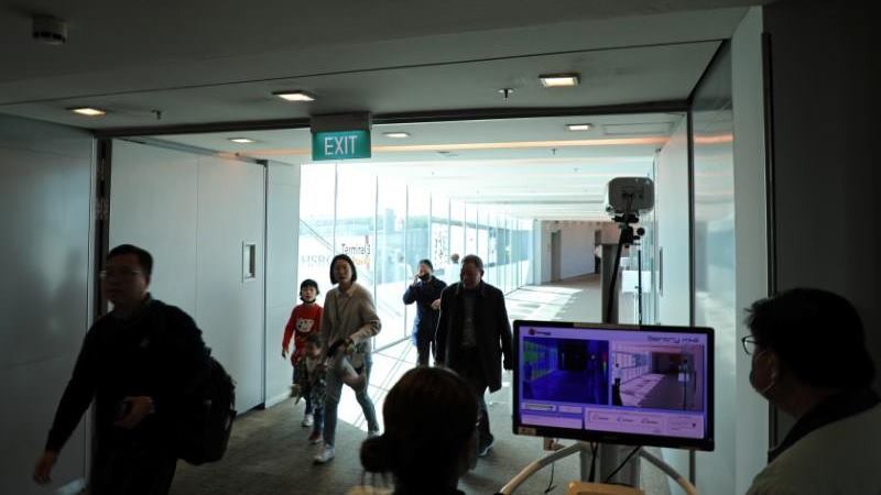 Petugas bandara memantau pemindai termal saat penumpang lewat setelah kedatangan penerbangan dari Hangzhou, China di Bandara Changi, Singapura, 22 Januari 2020. -  REUTERS / Yiming Woo