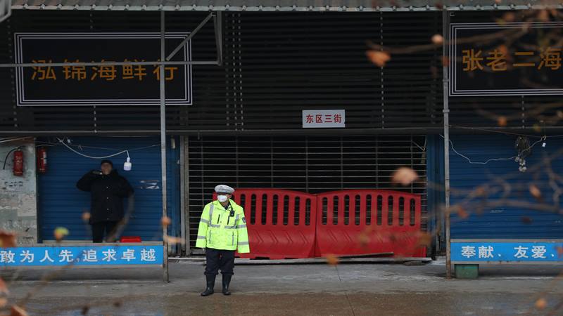 Seorang petugas polisi mengenakan masker berdiri di depan pasar makanan laut di Wuhan, Provinsi Hubei, China 10 Januari 2020. Pasar makanan tersebut dihubungkan dengan wabah pneumonia yang disebabkan oleh strain baru coronavirus, tetapi beberapa pasien didiagnosis terinfeksi coronavirus baru tidak berkunjung ke pasar ini. Foto diambil 10 Januari 2020. - Reuters