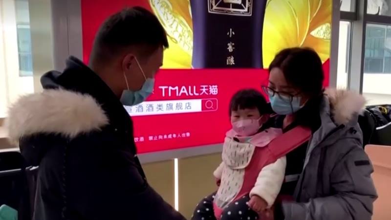 Keluarga mengenakan masker, termasuk anak-anak di  stasiun kereta di Provinsi Hubei China, 22 Januari 2020. - Reuters 