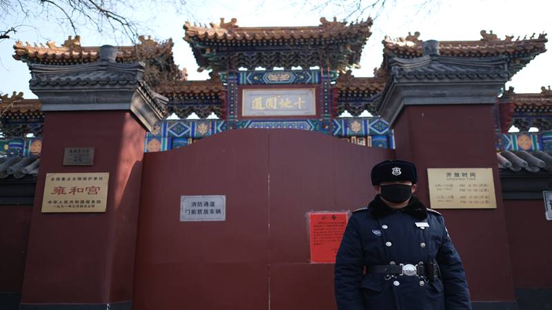 Seorang petugas polisi berjaga-jaga di depan gerbang tertutup Kuil Lama. Kuil itu ditutup setelah  wabah coronavirus baru di Beijing, China 25 Januari 2020.  - Reuters