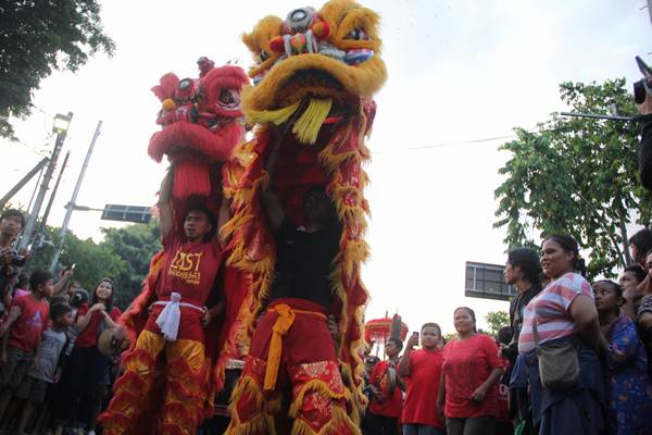 Warga Denpasar menyaksikan parade budaya di Jalan Gajah Mada, Sabtu (25/1/2020). Event ini digelar dalam rangka perayaan Imlek 2571 yang menampilkan atraksi Barongsai, Barong Macan, Barong Landung, Barong Bangkung, hingga Celuluk. - Bisnis/Busrah Ardans