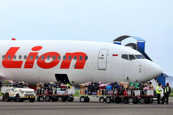 Pekerja melakukan bongkar muat bagasi penumpang pesawat Lion Air, di Bandara Husein Sastranegara Bandung, Jawa Barat. - Bisnis/Rachman