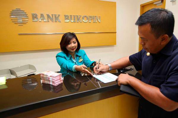 Karyawati melayani nasabah, di kantor Cabang Bank Bukopin di Jakarta, Senin (9/4/2018). - JIBI/Abdullah Azzam