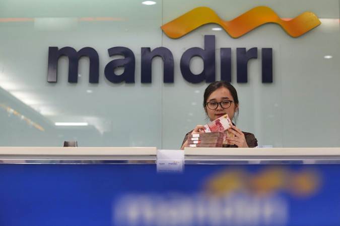 Karyawati menghitung uang pecahan Rp100.000 di salah satu kantor cabang milik Bank Mandiri, di Jakarta, Rabu (12/6/2019). - Bisnis/Nurul Hidayat