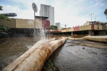 Selang air memompa banjir yang menutup Underpass Kemayoran, Jakarta, Minggu (2/2/2020). Banjir di kawasan tersebut diakibatkan intensitas hujan yang tinggi dan drainase yang buruk. ANTARA FOTO/Rivan Awal Lingga - foc.