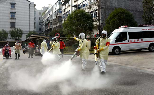 Relawan menggunakan pakaian pelindung saat membasmi kuman di perumahan untuk mengantisipasi wabah virus coronadi Taizhou, Provinsi Zhejiang, China (30/1 -  2020). China Daily via Reuters
