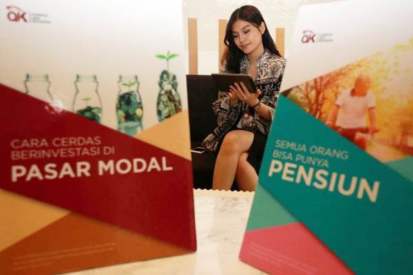 Model membaca e-Book Literasi Keuangan saat peluncurannya, di Jakarta, Kamis (6/7). OJK memperbarui materi buku literasi keuangan tingkat SMA melalui versi elektronik dan menerbitkan buku literasi keuangan untuk segmen profesional dan pensiunan. JIBI/Bisnis - Abdullah Azzam