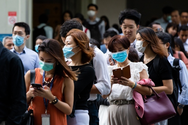 Warga mengenakan masker sebagai bentuk pencegahan atas virus corona, di kawasan pusat bisnis Singapura, Senin (10/2/2020). - Bloomberg/Seong Joon Cho