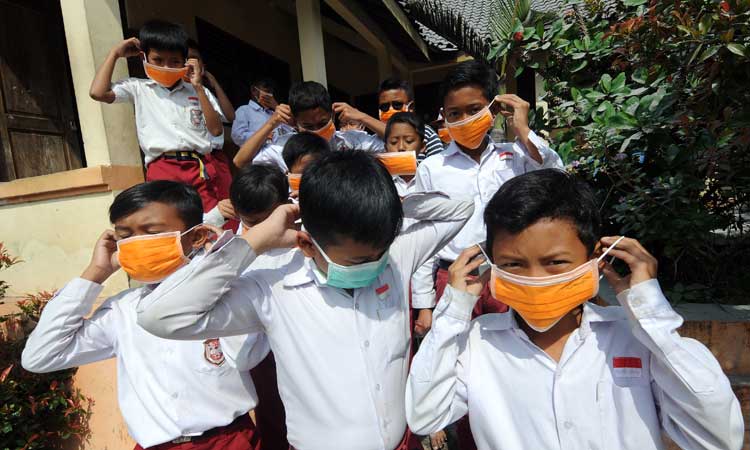 Sejumlah siswa menggunakan masker yang dibagikan oleh Badan Penanggulangan Bencana Daerah (BPBD) Kabupaten Boyolali pascaletusan gunung Merapi di SD N 1 Ringinlarik, Musuk, Boyolali, Jawa Tengah, Selasa (3/3/2020). Masker tersebut dibagikan kepada masyarakat lereng Gunung Merapi untuk melindungi saluran pernapasan dari abu vulkanik pascaletusan Gunung Merapi. ANTARA FOTO - Aloysius Jarot Nugroho