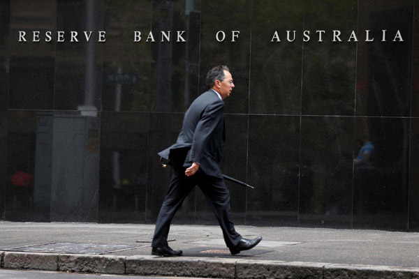 Seorang pebisnis melintasi kantor bank sentral Australia (Reserve Bank of Australia) di Sydney. - Reuters/Jason Reed