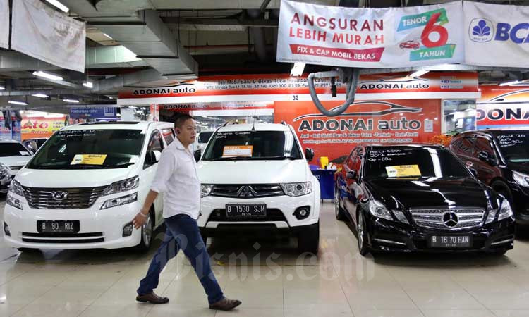 Pengunjung melintasi deretan mobil bekas yang dijual di Jakarta, Selasa (3/3/2020). Bisnis - Eusebio Chrysnamurti
