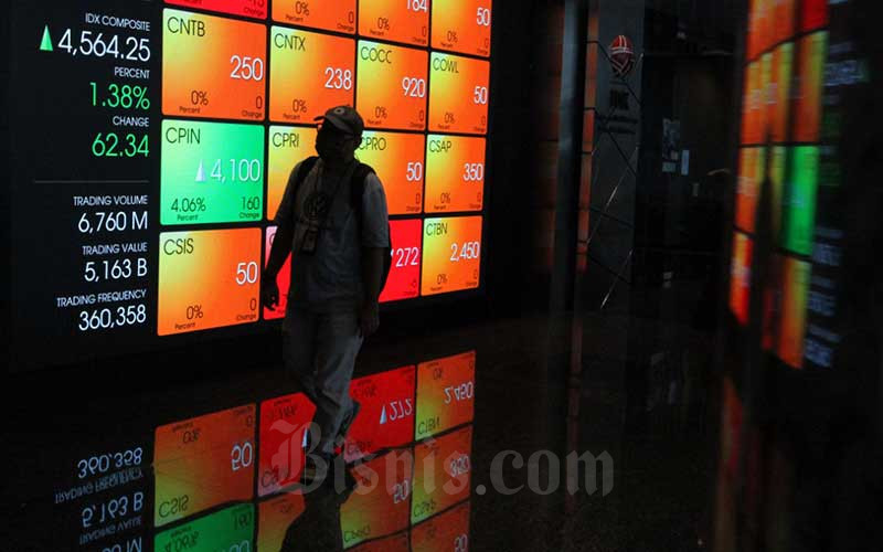 Pengunjung melintas didekat papan elektronik yang menampilkan perdagangan harga saham di Jakarta, Rabu (22/4/2020). Bisnis - Dedi Gunawan