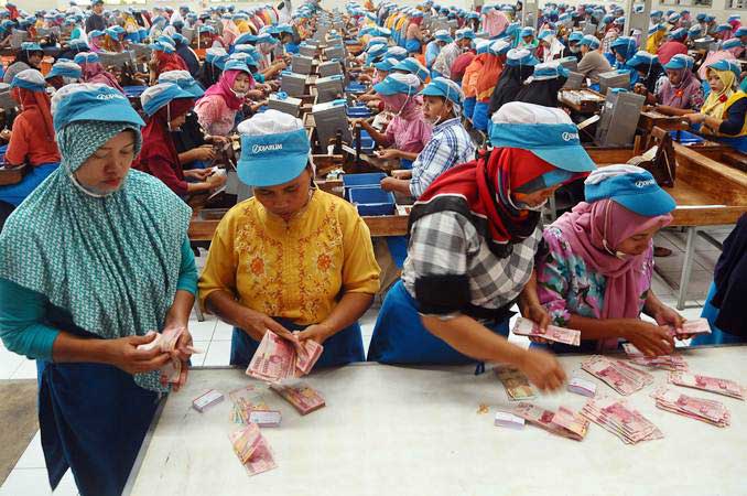 Sejumlah pekerja pabrik rokok menghitung uang Tunjangan Hari Raya (THR) Lebaran saat pembagian di Kudus, Jawa Tengah, Selasa (21/5/2019). - ANTARA/Yusuf Nugroho