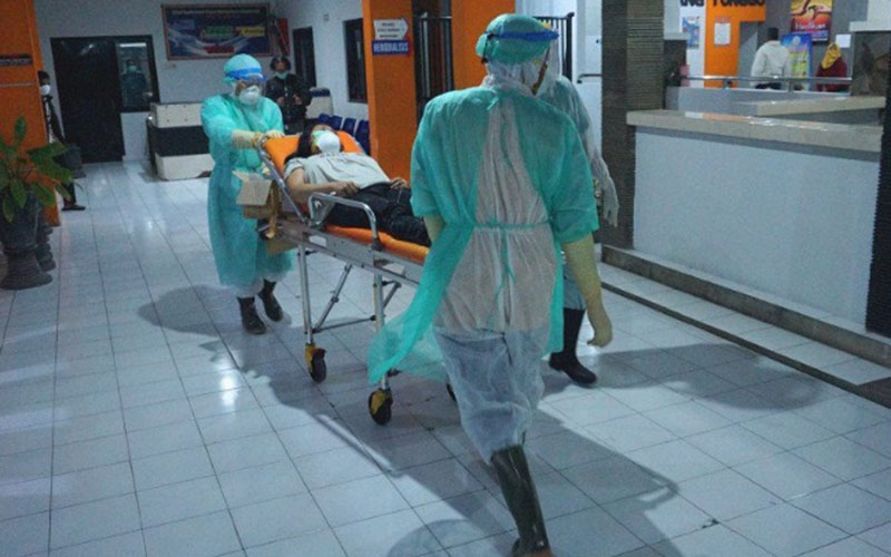 Petugas medis mengenakan alat pelindung diri mendorong ranjang beroda tempat pasien berstatus dalam pengawasan corona menuju ruang isolasi RSUD dr. Iskak di Tulungagung, Jawa Timur, pada Jumat (13/3/2020). - Antara