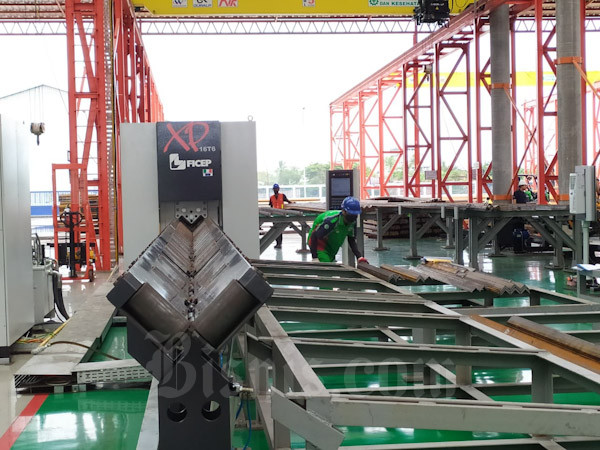 Pekerja pabrik menyusun bagian menara saluran tegangan ekstra tinggi (SUTT) yang baru saja di olah dari baja canai panas (HCR) di pabrik PT Waskita Karya Infrastruktur. Pabrik tersebut memiliki kapasitas produksi bagian menara SUTET 48.000 ton per tahun.