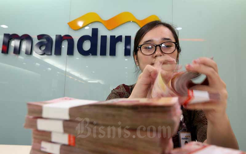 Karyawati menghitung uang pecahan uang Rp100.000 di salah satu kantor cabang milik PT Bank Mandiri Tbk di Jakarta, Rabu (12/6/2019). Bisnis - Nurul Hidayat
