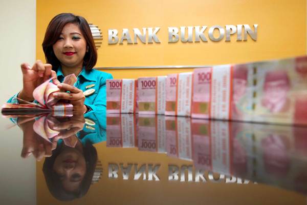 Karyawati menghitung uang rupiah, di kantor Cabang Bank Bukopin di Jakarta, Senin (9/4/2018). - JIBI/Abdullah Azzam