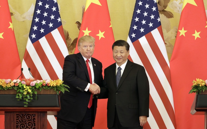 Presiden AS Donald Trump dan Presiden China Xi Jinping bersalaman dalam konferensi pers di Great Hall of the People di Beijing, China, Kamis (9/11/2017). - Bloomberg/Qilai Shen\n