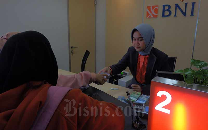 Karyawan melayani nasabah di salah satu kantor cabang milik PT Bank Negara Indonesia (Persero) Tbk. yang ada di Jakarta, Senin (25/2). Bisnis - Nurul Hidayat