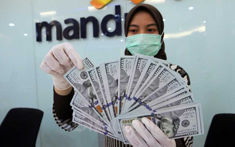 Karyawati bank menata uang dollar di kantor cabang PT Bank Mandiri Tbk. di Jakarta, Rabu (22/4/2020). Bisnis - Dedi Gunawan