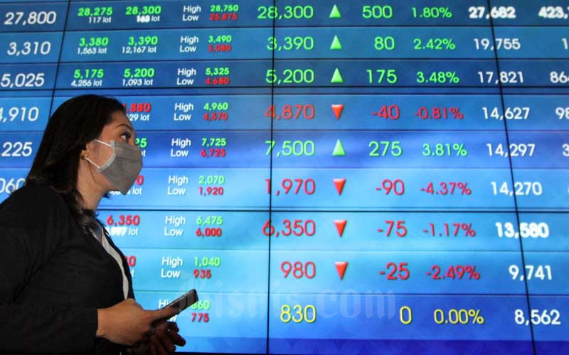 Pengunjung berada didekat papan elektronik yang menampilkan perdagangan harga saham di lantai Bursa Efek Indonesia di Jakarta, Jumat (13/3/2020). Bisnis - Dedi Gunawan