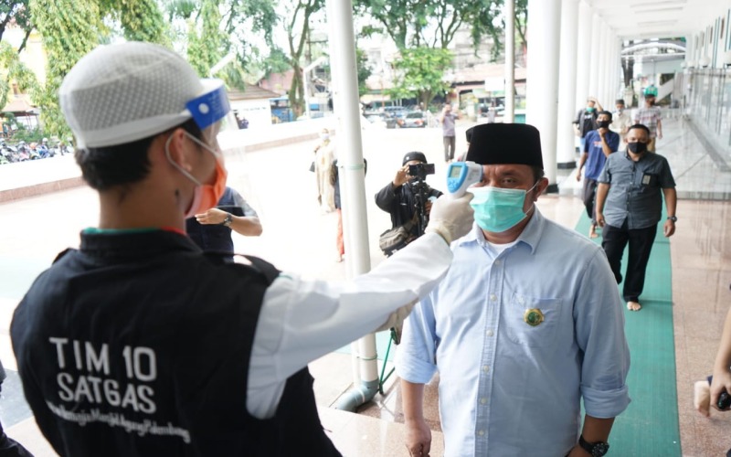 Petugas masjid memeriksa suhu tubuh Gubernur Sumsel Herman Deru saat memasuki Masjid Agung Palembang sesuai dengan protokol kesehatan. istimewa