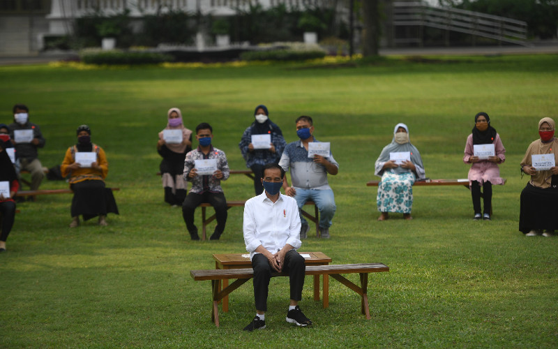 Presiden Joko Widodo (tengah) berfoto bersama usai memberikan bantuan modal kerja kepada pedagang kecil yang terdampak COVID-19 di halaman tengah Istana Merdeka, Jakarta, Selasa (21/7/2020). Presiden memberikan bantuan sebesar Rp2,4 juta kepada masing-masing pedagang.  - ANTARA