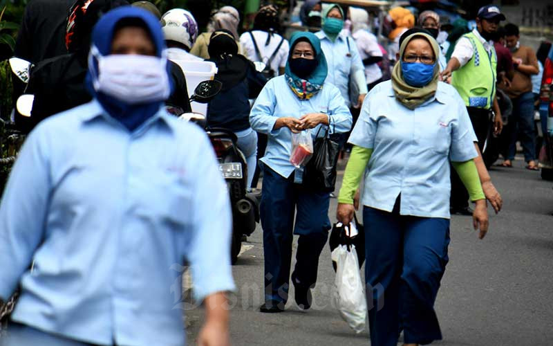 Pekerja pabrik pulang seusai bekerja di salah satu pabrik makanan di Jakarta, Sabtu (11/4/2020). Bisnis - Abdurachman