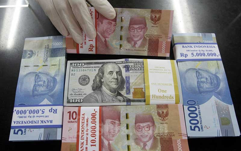 Karyawati menunjukan Uang Rupiah dan Dollar AS di salah satu kantor cabang Bank BNI di Jakarta, Kamis (3/9/2020).  Bisnis - Himawan L Nugraha
