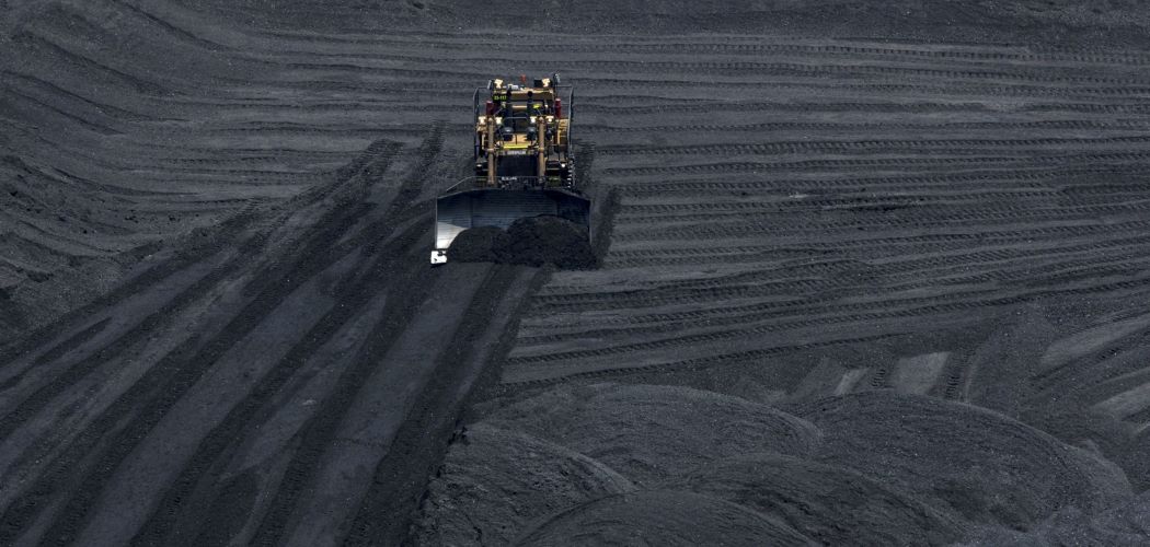 Ilustrasi - Alat berat membersihkan area penimbunan batu bara. -  Bloomberg / Nicolo Filippo Rosso