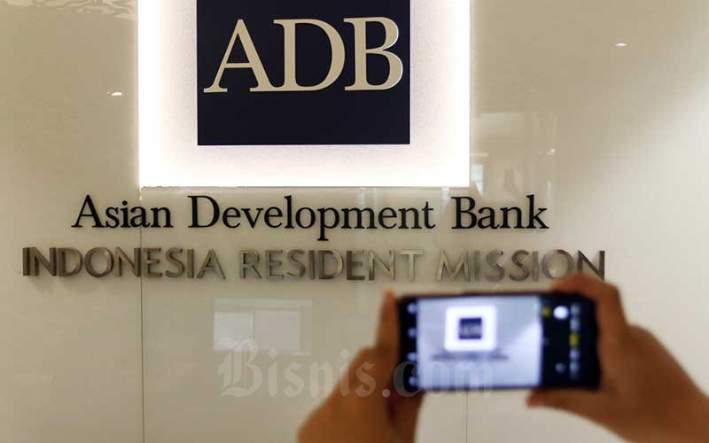 Karyawan memotret logo Asian Development Bank Indonesia di Jakarta, Rabu (8/4/2020). Bisnis - Eusebio Chrysnamurti