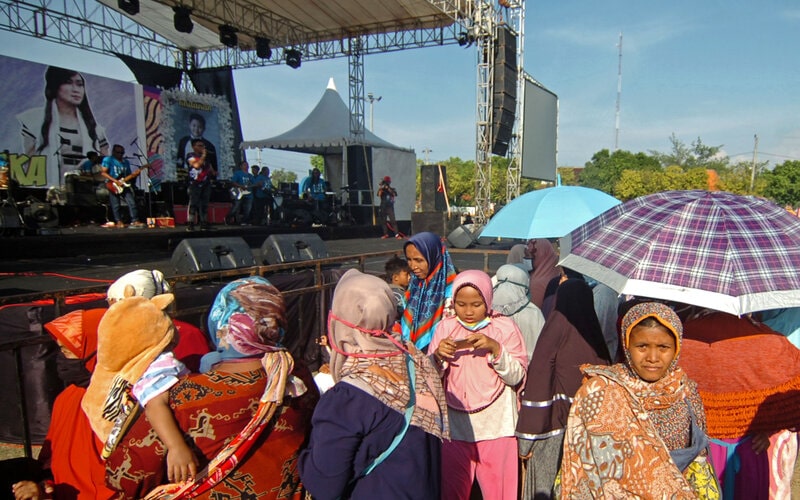 Sejumlah warga tidak mengenakan masker menyaksikan musik dangdut di Lapangan Tegal Selatan, Tegal, Jawa Tengah, Rabu (23/9/2020). Konser musik dangdut yang diadakan Wakil Ketua DPRD Kota Tegal Wasmad untuk perayaan pernikahan di tengah pandemi COVID-19 tersebut dihadiri banyak warga yang tidak menerapkan protokol kesehatan dengan tidak memakai masker dan tidak jaga jarak. - Antara/Oky Lukmansyah