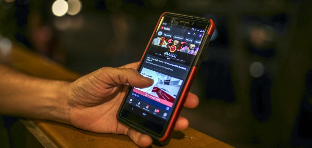Seorang warga menonton video di YouTube melalui smartphone di Mumbai, India, Sabtu (15/2/2020). - Bloomberg/Dhiraj Singh