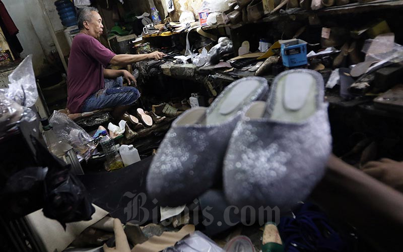 Pengrajin menyelesaikan pembuatan alas sepatu di Jakarta, Jumat (17/1). Bisnis - Abdullah Azzam