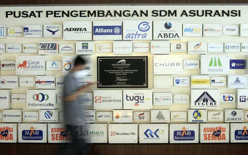 Karyawan beraktifitas di dekat deretan logo-logo perusahaan asuransi di Kantor Asosiasi Asuransi Umum Indonesia (AAUI) di Jakarta, Selasa (22/9/2020). Bisnis - Himawan L Nugraha