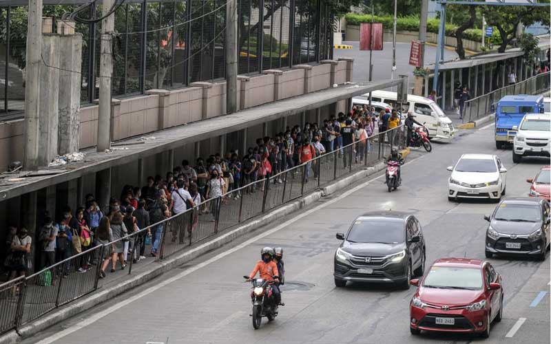 Penumpang mengantri untuk naik kereta Mass Rapid Transit (MRT) menjelang jam malam yang diberlakukan karena corona virus di Mandaluyong City, Metro Manila, Filipina, Senin (16/3/2020). Bloomberg - Veejay Villafranca 