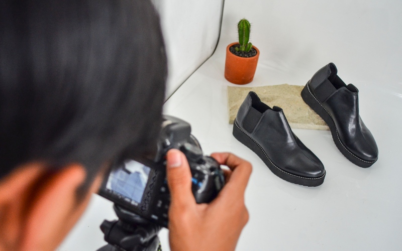 Pekerja memotret produk sepatu Prospero yang akan dipasarkan melalui platform digital di Kota Tasikmalaya, Jawa Barat, Jumat (3/7/2020). Menurut data Kementerian Komunikasi dan Informatika, sebanyak 9,4 juta UMKM sudah menggunakan atau memasarkan produknya melalui pasar e-commerce dan mendapatkan manfaat penggunaan teknologi digital untuk transaksi lintas batas. - ANTARA FOTO/Adeng Bustomi