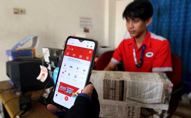 Pelanggan menggunakan aplikasi LinkAja di salah satu outlet JNE di Jakarta, Senin (10/2/2020). Bisnis - Arief Hermawan P
