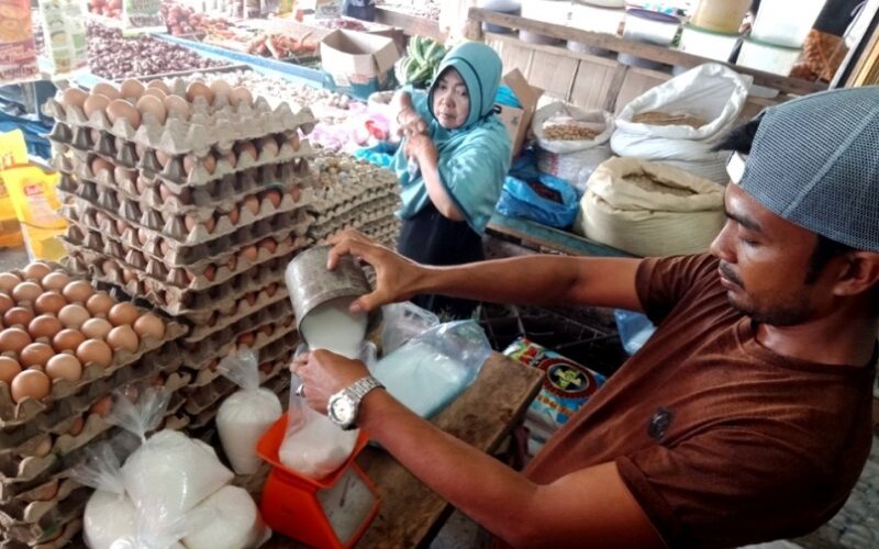 Seorang pedagang di Pasar Bina Usaha Meulaboh, Kabupaten Aceh Barat, mengecer gula pasir ke dalam bentuk kemasan satu kilogram sebelum dijual ke konsumen, Minggu (5/4/2020). - Antara/Teuku Dedi Iskandar\n