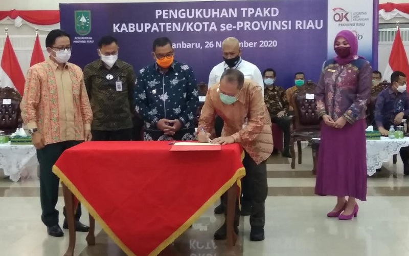 Direktur BRK Andi Buchari menandatangani komitmen pembinaan desa inklusi bersama Wakil Gubernur Riau, Kepala OJK Riau dan pejabat lainnya di Balai Serindit, Komplek Gubernur Riau, Kamis (26/11/2020).  - Bisnis/Eko Permadi