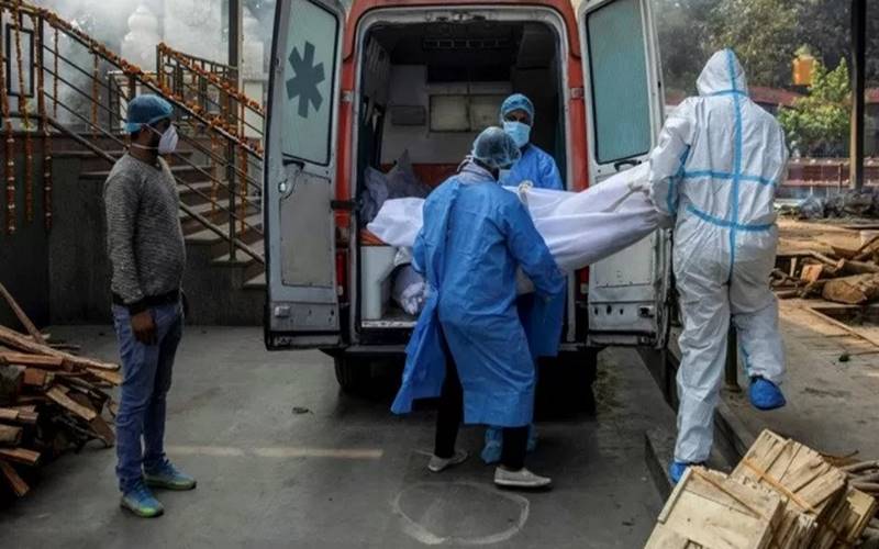 Tenaga kesehatan dan kerabat membawa jenazah seorang pria, yang meninggal dunia akibat penyakit  Covid-19 dari ambulans ke krematorium di New Delhi, India, Jumat (13/11/2020). - Antara/Reuters\r\n