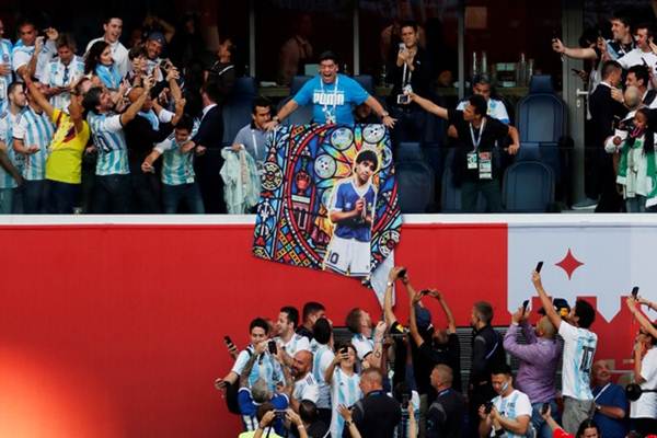 Diego Maradona memampangkan poster dirinya saat Argentina vs Nigeria di Piala Dunia 2018, Rabu (27/6/2018) di Rusia - Reuters