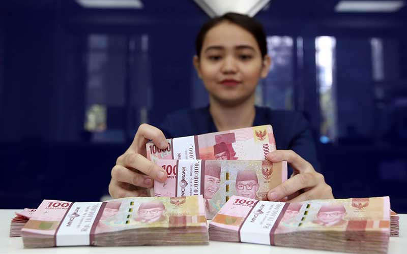 Karyawan menghitung uang pecahan Rp.100.000 di salah satu Bank yang ada di Jakarta, Senin (4/6). Bisnis - Abdullah Azzam