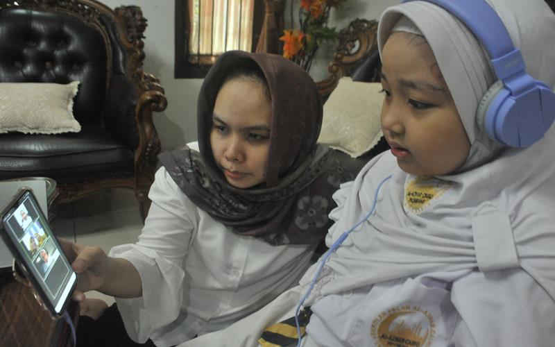 Siswa Sekolah Dasar didampingi orang tua melakukan Pembelajaran Jarak Jauh (PJJ) dengan sistem daring pada hari pertama tahun ajaran baru 2020-2021 di Palembang, Sumatera Selatan, Senin (13/7/2020). ANTARA FOTO - Feny Selly