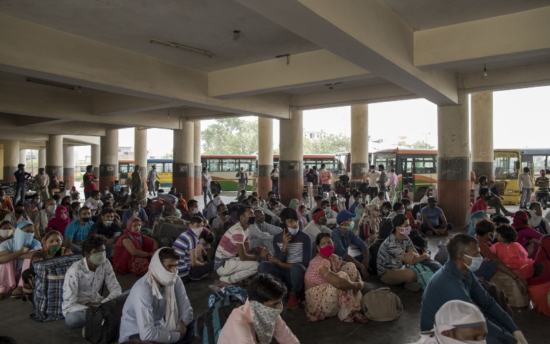 Pekerja migran menunggu di terminal bus untuk pulang ke kampung halaman masing-masing, di Greater Noida, Uttar Pradesh, India, Jumat (29/5/2020). - Bloomberg/Anindito Mukherjee