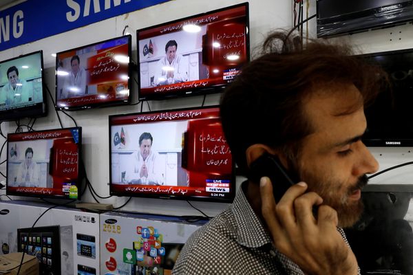 Ilustrasi. Seorang penjaga toko elektronik berbicara di telepon, di hadapan layar televisi, Kamis (26/7). - Reuters/Akhtar Soomro