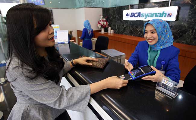 Karyawan melayani nasabah yang melakukan transaksi di kantor cabang Bank BCA Syariah di Jakarta. Bisnis - Abdullah Azzam