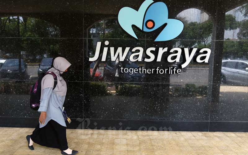 Warga melintasi logo Asuransi Jiwasraya di Jakarta, Senin (5/10/2020). - Bisnis/Eusebio Chrysnamurti