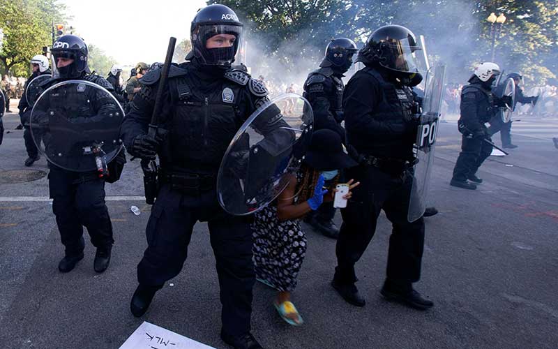 Seorang demonstran mencoba melewati garis polisi yang mengenakan pakaian anti huru hara ketika mereka mendorong kembali demonstran di luar Gedung Putih, Washington, Amerika Serikat, Senin (1/6/2020). Bloomberg/AFP via Getty Images - Jose Luis Magana 